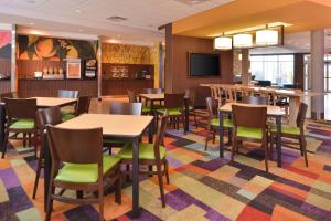 a dining room with tables and chairs and a flat screen tv at Fairfield Inn and Suites by Marriott Calhoun in Calhoun
