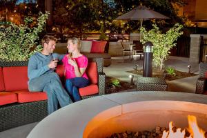 a man and woman sitting on chairs next to a fire pit at Residence Inn by Marriott Omaha Downtown Old Market Area in Omaha +38 photos