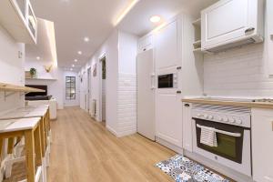 Una cocina con gabinetes blancos y una estufa. en Roomscapital, en Bilbao 6 fotos más