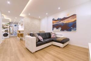 Una sala de estar con un sofá y un cuadro en la pared. en Roomscapital, en Bilbao