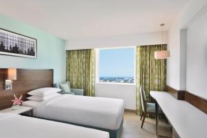 ein Hotelzimmer mit 2 Betten und einem Fenster in der Unterkunft Fairfield by Marriott Chennai OMR in Chennai