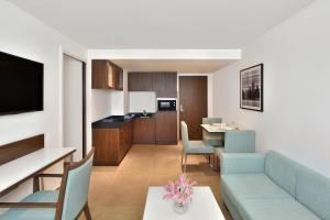 Fairfield by Marriott Chennai OMR في تشيناي: غرفة معيشة مع أريكة وغرفة طعام