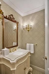 ein Bad mit einem Waschbecken und einem Spiegel in der Unterkunft The Hotel Saskatchewan, Autograph Collection in Regina