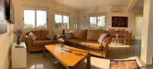 una sala de estar con 2 sofás marrones y una mesa. en Sunrise Villa 11 in Ayia Thekla en Ayia Napa