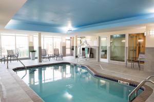 a swimming pool in a building with tables and chairs at Fairfield Inn & Suites by Marriott Sheridan in Sheridan