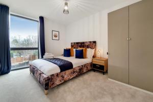 a bedroom with a large bed and a large window at Luxury Harrow Wembley Apartment in Harrow