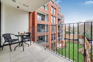 a balcony with a table and chairs on it at Luxury Harrow Wembley Apartment in Harrow
