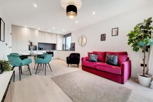 a living room with a red couch and a table at Luxury Harrow Wembley Apartment in Harrow