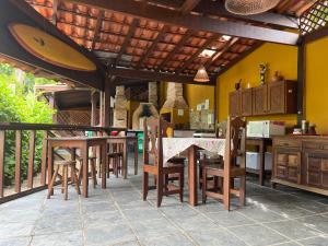 a kitchen with wooden chairs and a table in a kitchen at Itamambuca Suites in Ubatuba