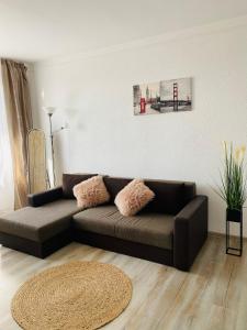 een woonkamer met een bruine bank en een tapijt bij City Center Apartments - Piața Unirii in Iaşi