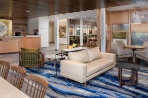 Fairfield Inn & Suites by Marriott Knoxville Lenoir City/I-75 في مدينة لينوير: غرفة معيشة مع أريكة وكراسي على سجادة
