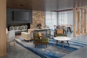 ein Wohnzimmer mit einem Sofa, Stühlen und einem Kamin in der Unterkunft Fairfield Inn & Suites by Marriott Santa Rosa Rohnert Park in Rohnert Park