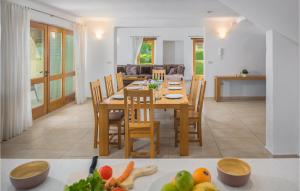 a dining room and living room with a table and chairs at Awesome Home In Baredine With 4 Bedrooms And Outdoor Swimming Pool in Donje Baredine