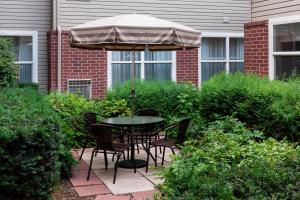a table and chairs under an umbrella on a patio at Residence Inn by Marriott Provo in Provo