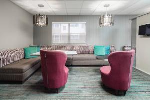 uma sala de espera com sofás e uma mesa e cadeiras em Residence Inn by Marriott Provo em Provo