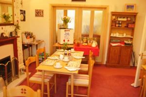 a dining room with a table and chairs and a kitchen at Robyn's Guest House in Scarborough