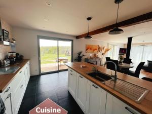 a kitchen with white cabinets and a counter with a sink at Maison au calme à 5min de Cognac pour 1 à 8 pers in Richemont +18 photos