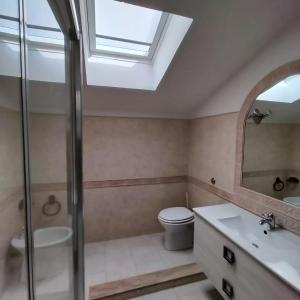ein Badezimmer mit einem Waschbecken, einem WC und einem Dachfenster in der Unterkunft La Petite Maison in Quartu SantʼElena