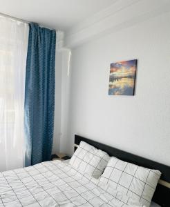 a bedroom with a bed and a blue curtain at City Center Apartments - Piața Unirii in Iaşi