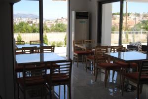 a dining room with tables and chairs and windows at Philoxenia in Thiva