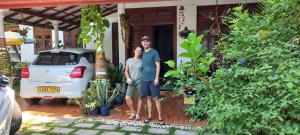 a man and a woman standing in front of a house at Abinu"s Place in Dickwella