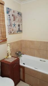 a bathroom with a tub and a toilet and a sink at The Big tree @ Sabie in Sabie