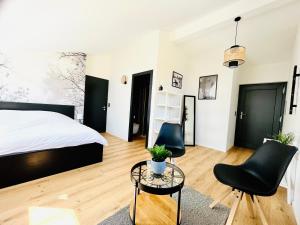 a bedroom with a bed and two chairs and a table at Chambre double privative et indépendante in Flanthey