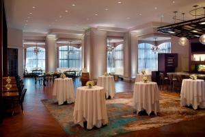 um salão de banquetes com mesas, cadeiras e mesa em New Orleans Marriott Metairie At Lakeway em Metairie