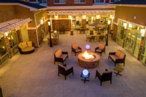 un patio al aire libre con una hoguera, mesas y sillas en Residence Inn by Marriott Richmond at the Notch, en Richmond