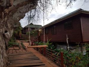 a wooden house with a porch and a fence at The Big tree @ Sabie in Sabie