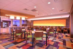 una zona de comedor con mesas y sillas en un restaurante en Fairfield Inn & Suites by Marriott St. Louis Pontoon Beach/Granite City, IL en Collinsville