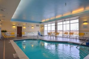 una gran piscina con sillas y mesas en un edificio en Fairfield Inn & Suites by Marriott St. Louis Pontoon Beach/Granite City, IL, en Collinsville