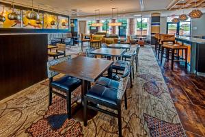 Courtyard by Marriott Oxford في أكسفورد: مطعم بطاولات وكراسي وبار