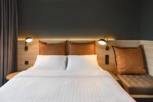 a bedroom with a large bed and a couch at Moxy Stuttgart Feuerbach in Stuttgart