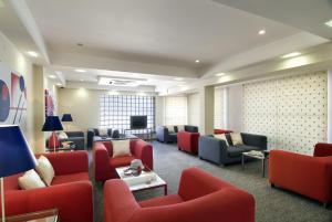 a waiting room with couches and chairs and a tv at Hotel Cruz Alta in Fátima