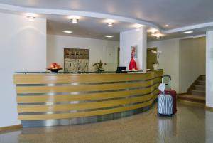un hall d'hôtel avec un comptoir de réception et une valise dans l'établissement Hotel Cruz Alta, à Fátima