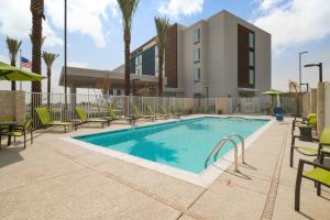 una piscina con sedie e un edificio di SpringHill Suites by Marriott Phoenix Goodyear a Goodyear