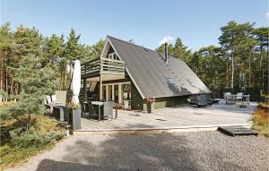 una casa con una gran terraza de madera en el bosque en 3 Bedroom Lovely Home In Nex, en Spidsegård