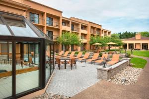 eine Terrasse mit Tischen und Stühlen vor einem Gebäude in der Unterkunft Courtyard Philadelphia Willow Grove in Willow Grove