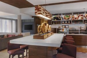 a kitchen with a large white counter with brown chairs at Courtyard Philadelphia Willow Grove in Willow Grove