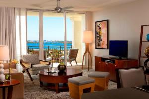 a living room with a couch and a television at Palm Beach Marriott Singer Island Beach Resort & Spa in Palm Beach Shores