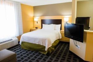 a hotel room with a bed and a flat screen tv at MainStay Suites Houston NASA-Clear Lake in Webster