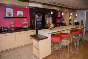 uma cozinha com um bar com bancos vermelhos em MainStay Suites Houston NASA-Clear Lake em Webster