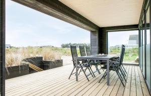 um pátio com uma mesa e cadeiras num deque em Stunning Home In Lkken With Outdoor Swimming Pool em Løkken