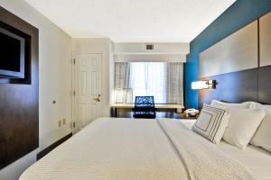 a bedroom with a large bed and a desk at Residence Inn by Marriott Jacksonville Airport in Jacksonville