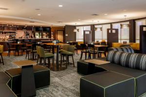 a restaurant with tables and chairs and a bar at Courtyard by Marriott Potomac Mills Woodbridge in Woodbridge