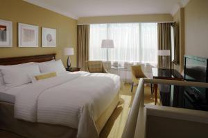 a hotel room with a large bed and a television at Warsaw Presidential Hotel in Warsaw