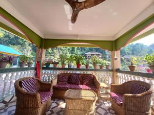 a porch with chairs and plants on a fence at Odyssey Stays Aalo in Along