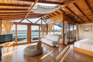 een slaapkamer met een bed, een bank en een tv bij Blu Galapagos Sustainable Waterfront Lodge in Puerto Ayora