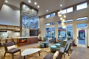 a lobby with chairs and tables and a fireplace at Residence Inn by Marriott Portland Clackamas in Clackamas